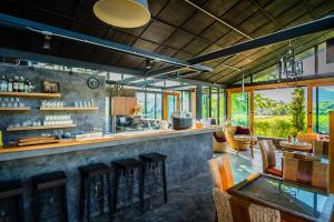 a bar in a restaurant with a lot of windows at Family House Zen Boutique Resort in Pai