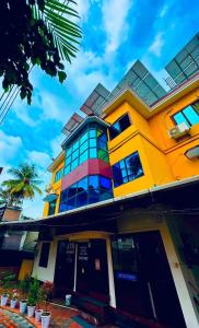 a yellow building with windows and a palm tree at New Jtr Residency in Ernakulam