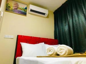 a bedroom with a bed with towels on it at Georgetown New Wave Hotel in George Town