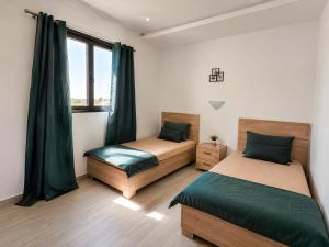 a bedroom with two beds and a window at Villa ines in Taguermess +2 photos