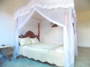 a bed with a canopy in a room at Japs Motel Mbarara in Ruhendwa