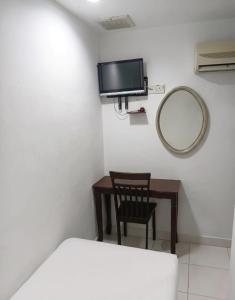 a small room with a mirror and a table and a mirror at Swing & Pillows - Kuala Selangor in Kuala Selangor