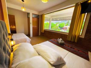 two beds in a room with a window at Runaway Hotel in Carhuaz +92 photos