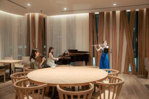 a woman playing a piano and two girls sitting at tables at Hotel GrandBach Sendai in Sendai +64 photos