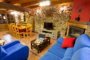 a living room with a blue couch and a fireplace at La Casita del Oja in Ojacastro