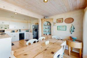 a kitchen and dining room with a wooden table and chairs at Oceanfront Delight in Cayucos