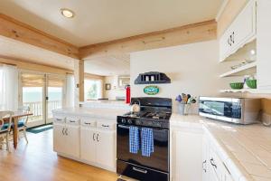 a kitchen with a stove and a counter top at Oceanfront Delight in Cayucos +17 photos