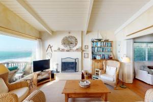 a living room with a fireplace and a television at Oceanfront Dream in Cayucos