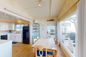 a kitchen with a table with chairs and a refrigerator at Oceanfront Dream in Cayucos +19 photos