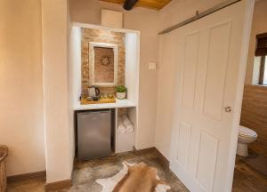 a bathroom with a toilet and a sink and a door at Singwe Private Safari Lodge Kruger in Marloth Park