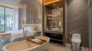 a bathroom with a tub and a sink and a toilet at Alcola Boutique Villa - Bahama Unit in Malang
