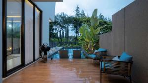 a living room with a pool and some chairs at Alcola Boutique Villa - Bahama Unit in Malang