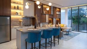 a kitchen with a island with blue bar stools at Alcola Boutique Villa - Bahama Unit in Malang