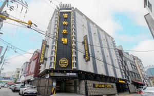 a large building with yellow writing on the side of it at Bupyeong Byulha Hotel in Incheon