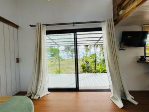 a room with a sliding glass door with a view of a deck at Private Sunset Beachfront Thainee Villa in Nathon Bay
