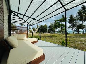 a porch with a bed and a view of the ocean at Private Sunset Beachfront Thainee Villa in Nathon Bay