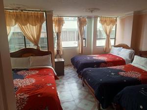 a bedroom with two beds and a window at Hotel Casa Nova in Tulcán