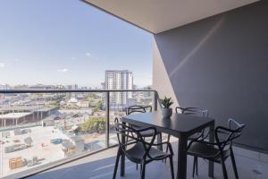 a dining room with a table and chairs and a large window at King Street Residences in Brisbane