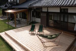 two chairs and a hammock on a wooden deck at 多古の里 l 300平米超の古民家を一棟贅沢貸切 l BBQ ドッグラン in Tako