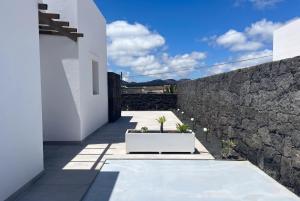 a courtyard of a house with a stone wall at Villa La Genuina in Yaiza