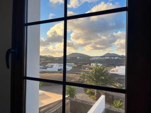 an open window looking out at a view of a city at Villa La Genuina in Yaiza