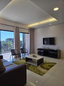 a living room with a couch and a tv at Marmen Apart-Dpto en CDE in Ciudad del Este