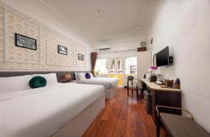 a hotel room with a large white bed and a desk at The Lake Silk Hotel & Travel in Hanoi +43 photos