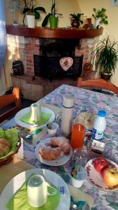 ein Tisch mit Tellern voller Essen und ein Kamin in der Unterkunft CasaRoman in San Floriano del Cóllio + 28 Fotos