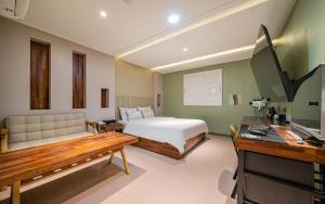 a bedroom with a bed and a desk with a computer at Bupyeong Byulha Hotel in Incheon
