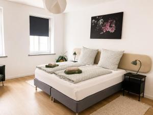 a bedroom with a bed with white walls at Modernes Design-Apartment mit Balkon & WLAN in Bautzen