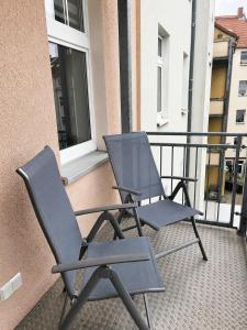 two chairs sitting on the balcony of a building at Modernes Design-Apartment mit Balkon & WLAN in Bautzen