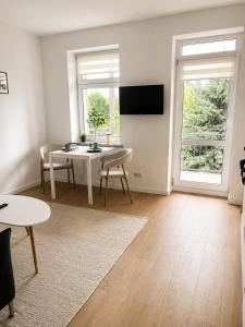 a living room with a table and a tv at Modernes Design-Apartment mit Balkon & WLAN in Bautzen