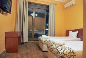 ヴェリコ・タルノヴォにあるArt Houseのベッド2台と窓が備わるホテルルームです。