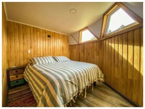 a bedroom with a bed and a window at Domos Frutillar in Frutillar