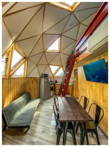 a room with a table and a couch and a ladder at Domos Frutillar in Frutillar