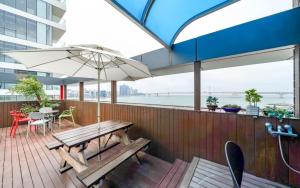 a deck with a bench and an umbrella at Busan Gwangalli SEAYOU HOTEL in Busan