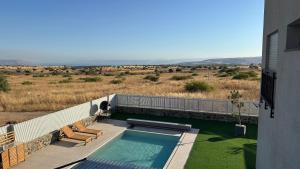 a swimming pool on the side of a house at Private Pool Retreat for Two - Golan in Qasrîne