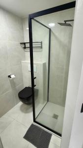 a bathroom with a glass shower with a toilet at Studio cosy Ducos in Ducos +2 photos