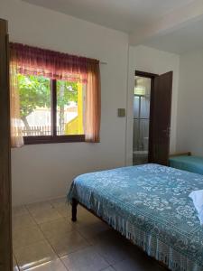 a bedroom with a bed and a window at Você vai sentir em casa in Itapoa