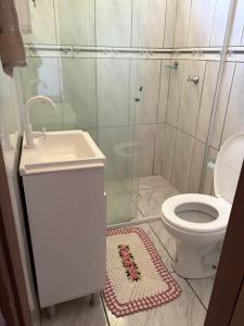 a bathroom with a toilet and a sink and a shower at Você vai sentir em casa in Itapoa
