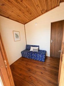 a small bed in a room with a wooden floor at Cabaña Acuña in Chuy