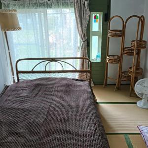 a bed sitting in a room with a window at Hakodate Guest House in Hakodate