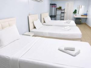 two beds in a room with white furniture at Magic Garden Residence Bangkok in Bangkok