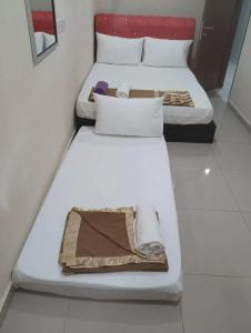 two beds in a small room with at Georgetown New Wave Hotel in George Town +3 photos