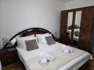 a bedroom with a large white bed with towels on it at Nano Apartmani in Smokvica +26 photos