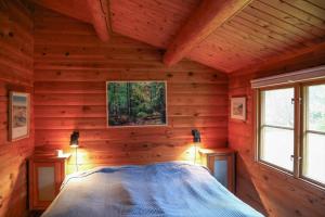 a bedroom with a bed in a log cabin at 10084-1-Rorvig-Sondervangen-12 in Rørvig