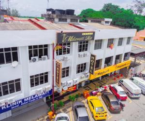 a building with cars parked in a parking lot at Swing & Pillows - Kuala Selangor in Kuala Selangor