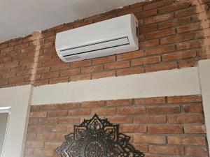 a air conditioner on the side of a brick wall at Alberca Privada a 15min del centro de la ciudad in Chihuahua