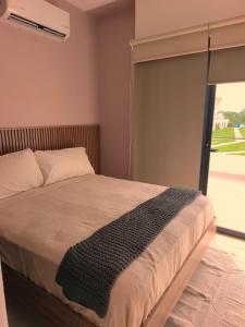 a bedroom with a bed and a sliding glass door at Puerto CARMA in Las Juntas