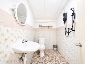 a bathroom with a sink and a toilet and a mirror at Magic Garden Residence Bangkok in Bangkok
